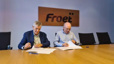 Firma del convenio de colaboraci&oacute;n y foto de grupo con los responsables de las empresas colaboradoras, FROET y C&aacute;ritas.