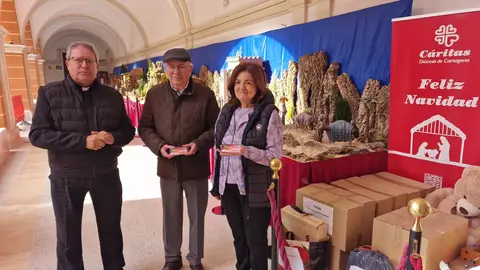 Luis Emilio Pascual, coordinador de la Sinf&oacute;nica de la UCAM; Jos&eacute; Antonio Planes, director de C&aacute;ritas, y Mar&iacute;a Dolores Garc&iacute;a, presidenta de la Universidad Cat&oacute;lica, durante la entrega de la recaudaci&oacute;n. (UCAM)