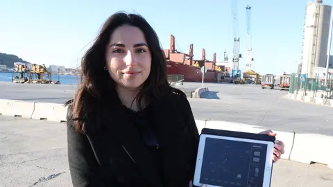 Mar&iacute;a Segado, en la d&aacute;rsena de Escombreras, mostrando un esquema de su trabajo para el modelo de gr&uacute;as que operan al fondo. (UPCT)