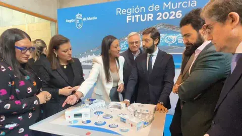 La consejera Carmen Conesa con los directores generales del &aacute;mbito tur&iacute;stico y algunos alcaldes asistentes al acto de presentaci&oacute;n de Fitur 2026, contemplando la maqueta del estand regional. (CARM)