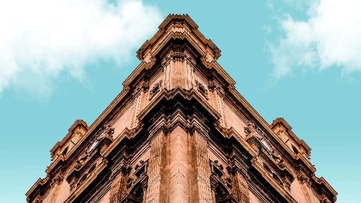 Descripción de la imagen: columna de la catedral de Murcia en España vista desde el suelo bajo el cielo azul