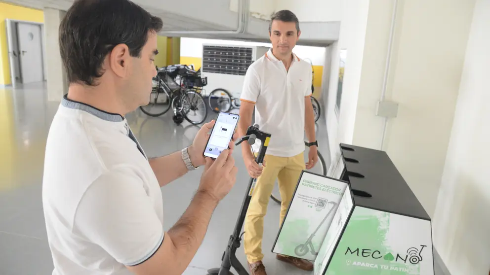 Los investigadores Jes&uacute;s Rubio y Jos&eacute; Santa probando la aplicaci&oacute;n para reservar los puntos de carga y estacionamiento seguro.