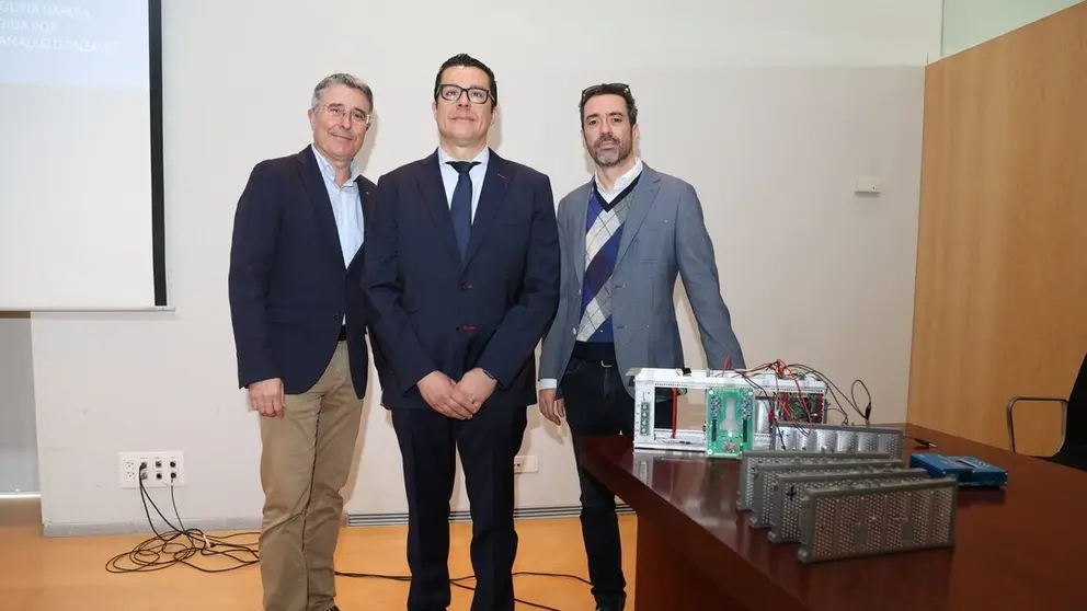 El autor de la tesis y sus directores junto a parte del sistema que han desarrollado para gestionar la carga de bater&iacute;as. (UPCT)