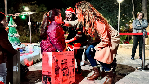 una ni&ntilde;a recoge su regalo de la Estrella de los Deseos en presencia de la alcaldesa