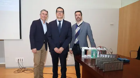 El autor de la tesis y sus directores junto a parte del sistema que han desarrollado para gestionar la carga de bater&iacute;as. (UPCT)