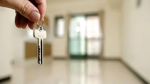 Apartment key in man hand in closeup view as house rental concept